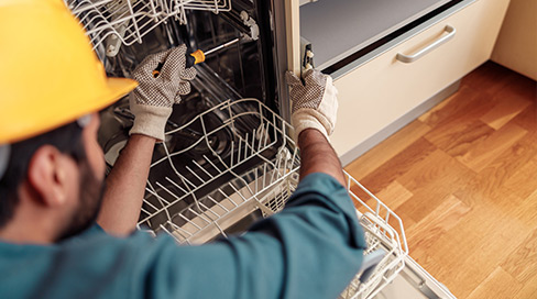 Certified appliance technician testing new dishwasher installation